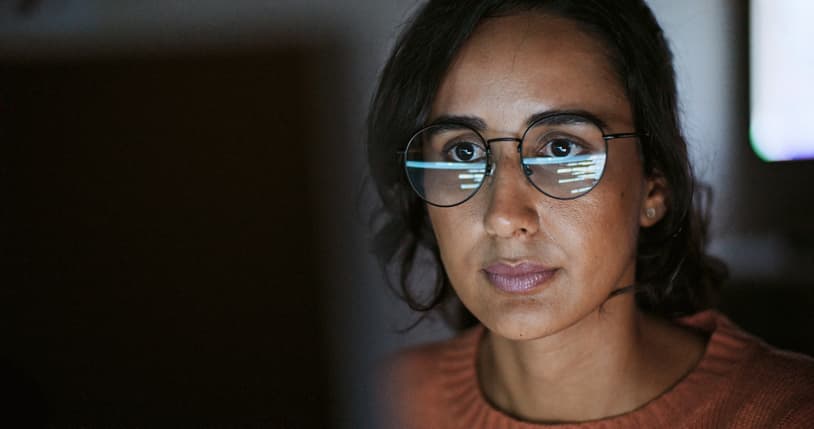 Woman looking at the laptop screen in front of her.