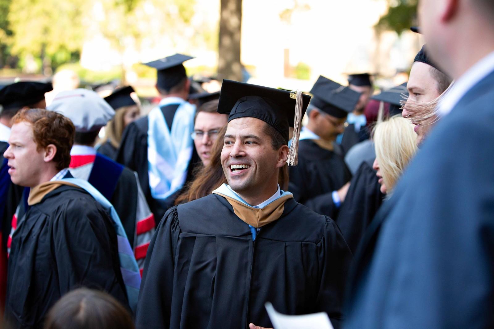 Man in graduation cap and gown at his graduation ceremony.