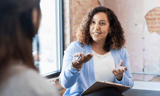 Woman communicating with another person using hand gestures.